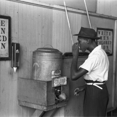 Un afro-american care bea dintr-un răcitor de apă segregat rasial