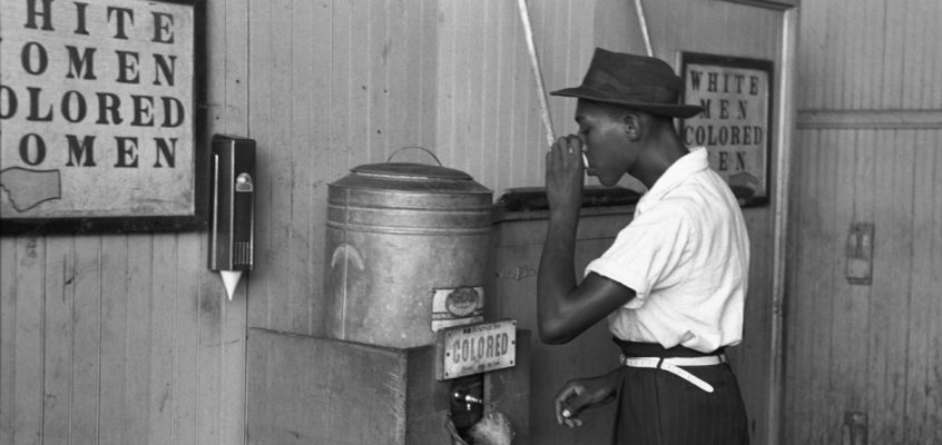 Un afro-american care bea dintr-un răcitor de apă segregat rasial