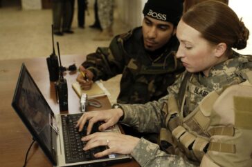 U.S. Army Sgt. Sarah L. Blair enters vital information of Iraqi policemen into a laptop computer