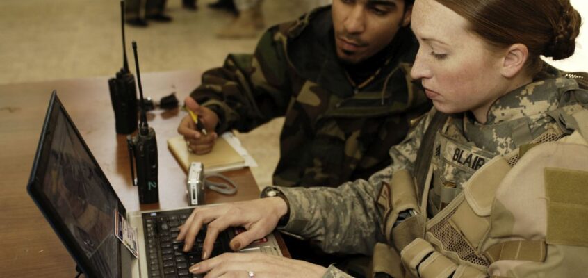 U.S. Army Sgt. Sarah L. Blair enters vital information of Iraqi policemen into a laptop computer